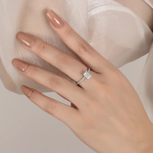 Women's hand wearing a silver ring with moissanite gemstone