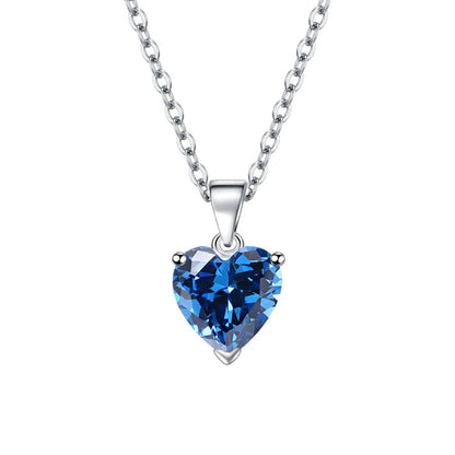 A heart-shaped blue crystal pendant necklace on a sterling silver chain, shown against a white background
