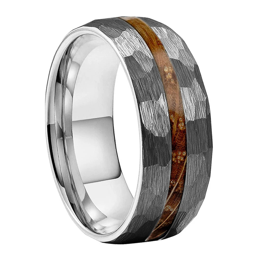 A silver-toned tungsten carbide ring with a textured hammered pattern and a central inlay of whiskey wood