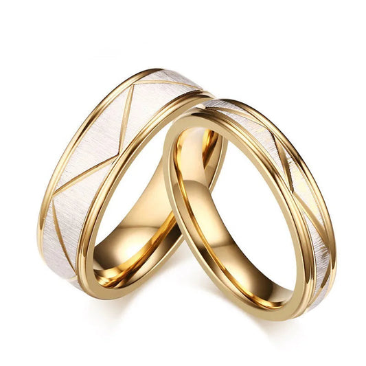 Two gold rings with geometric design on a white background