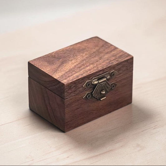 Wooden box with a brass latch on a light wooden surface