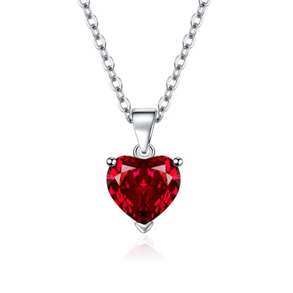 Silver heart-shaped crystal pendant necklace on a white background, featuring a faceted red heart gemstone in a silver setting with a silver chain