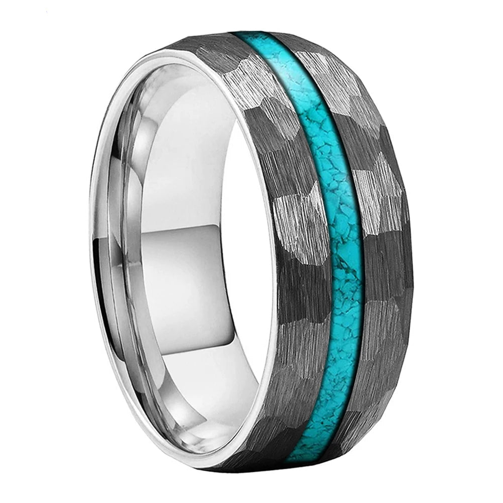 A tungsten carbide ring with a textured black and silver hammered pattern and a vibrant turquoise inlay