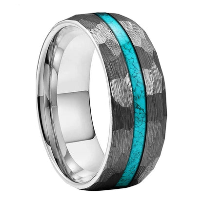A tungsten carbide ring with a textured black and silver hammered pattern and a vibrant turquoise inlay