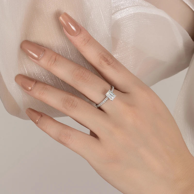 Women's hand wearing a silver ring with moissanite gemstone